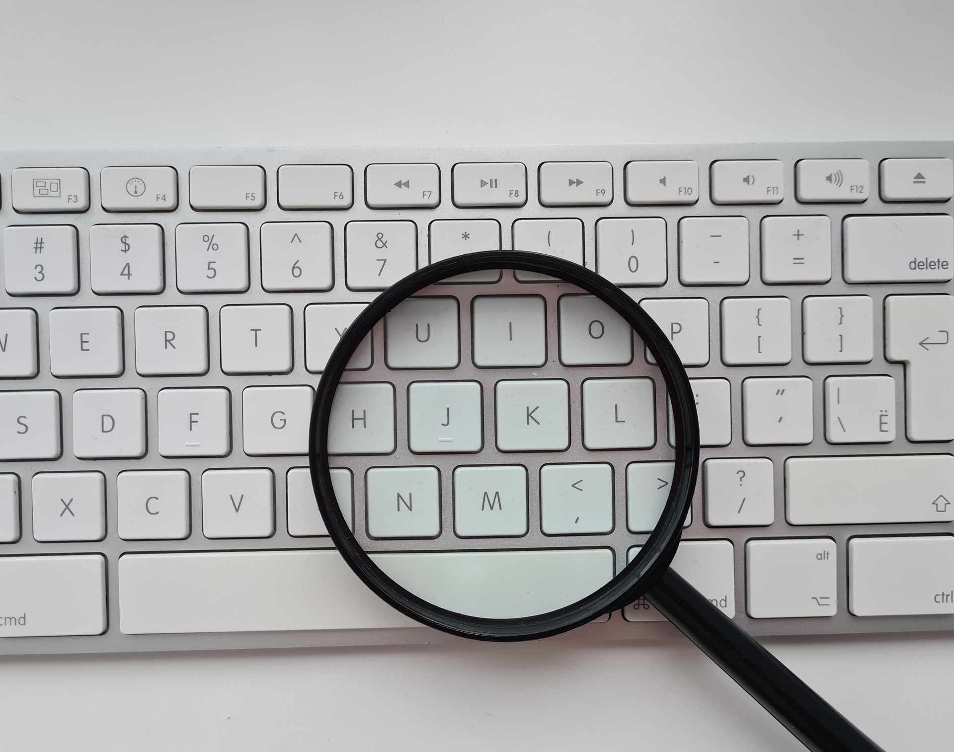 Magnifying glass on a computer white keyboard